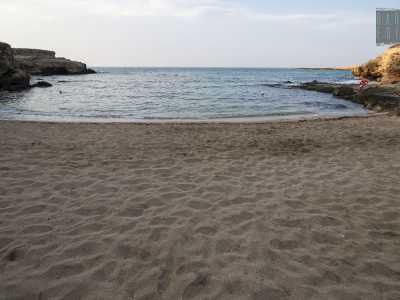 ...un ampio arenile incorniciato dagli scogli di solito occupato dagli ombrelloni del resort omonimo